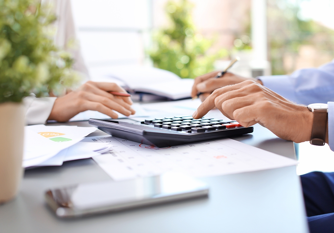 accountant using calculator on table